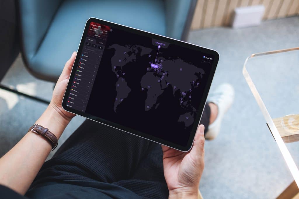 Person using tablet with world map with Proton VPN